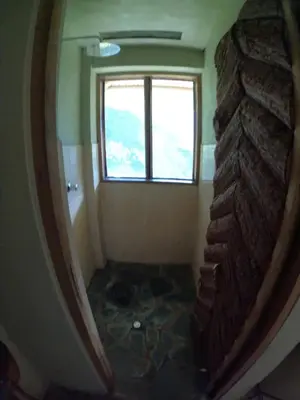 a room with a window and a stone wall at Salkantay Hostel Chaullay in Santa Teresa