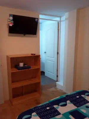 a bedroom with a flat screen tv on the wall at Hospedaje Kaihalulu in Punta Hermosa