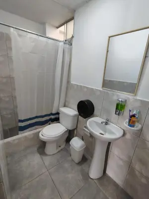 a bathroom with a toilet and a sink at Hospedaje Kaihalulu in Punta Hermosa