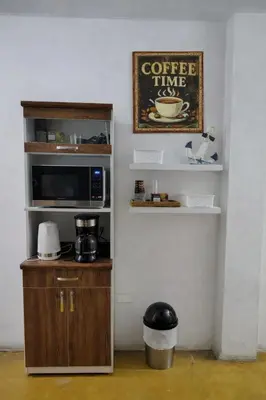 a kitchen with a coffee time sign and a microwave at Hospedaje Kaihalulu in Punta Hermosa