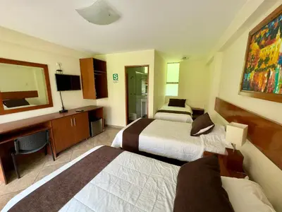 a hotel room with two beds and a television at Rio Lindo Ecolodge in Lunahuaná