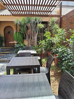 a patio with a table and chairs and a fence at Villas Del Sol Bed & Breakfast in Lima