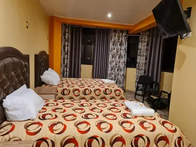 a bedroom with two beds and a window at Hostal Tuki Huancayo in Huancayo