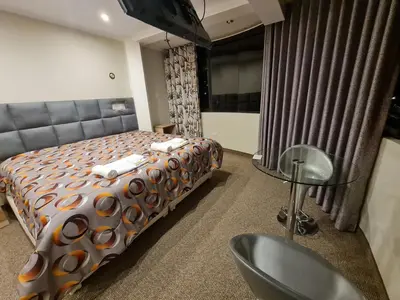 a bedroom with a bed and a chair and a table at Hostal Tuki Huancayo in Huancayo