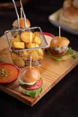 a wooden cutting board with sandwiches and french fries at Casa Tunki in Cusco