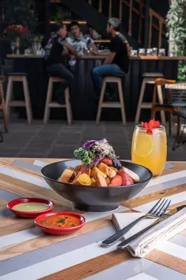a bowl of food sitting on a wooden table at Casa Tunki in Cusco