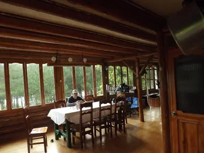 a person sitting at a table in a dining room at La Casita de Oxapampa in Oxapampa
