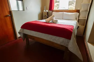 a bedroom with a bed with a teddy bear on it at Cochito Cusco in Cusco