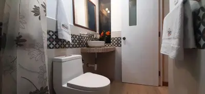 a bathroom with a white toilet and a sink at Hotel Garden House Huerta in Limatambo