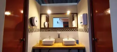 a bathroom with two sinks and a mirror at Hotel Garden House Huerta in Limatambo