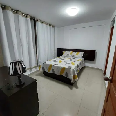 a bedroom with a bed and a lamp and curtains at Full apartment independent entrance, services included in Lima