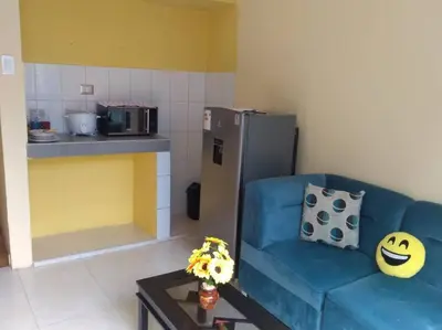 a living room with a blue couch and a kitchen at 101 Comfy Apt WiFi kitchen SmartTV Central at Callao in Lima