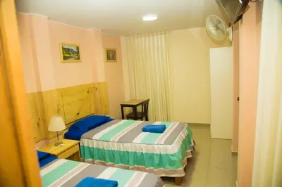 a hotel room with two beds and a table at Estancia Saraja in Ica