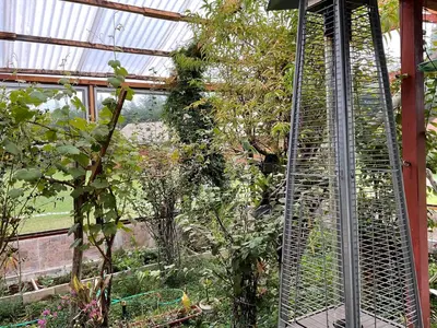 a greenhouse with a bird cage in a garden at RESORT ALAPA in Huancayo