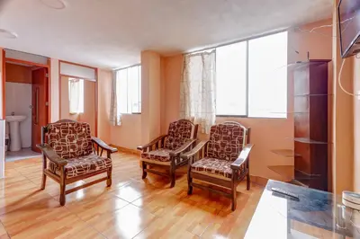 a living room with two chairs and a table at 402 Comfy Apt WiFi kitchen SmartTV Central at Callao in Lima