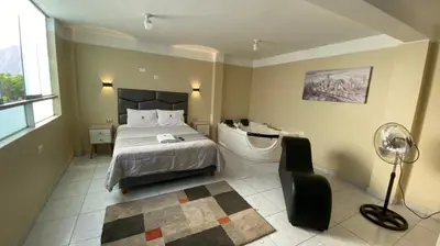 a bedroom with a bed and a desk and a window at HOTEL MAR Y LAGO in Lunahuaná