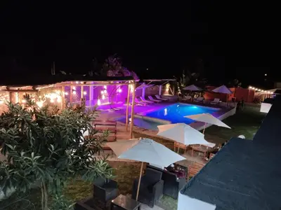 a swimming pool at night with umbrellas at HOTEL MAR Y LAGO in Lunahuaná