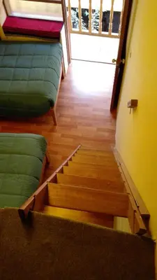 a room with stairs with green cushions and a door at B&B Chayana Wasi in Ollantaytambo