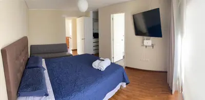 a bedroom with a blue bed and a television at Miraflores - Luxury Room in the Best Place in Lima