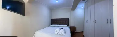 a bedroom with a bed with white sheets and white shoes at Miraflores - Luxury Room in the Best Place in Lima