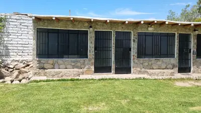 a stone building with black gates on it at Las Cabañas de Incahuasi in Lunahuaná