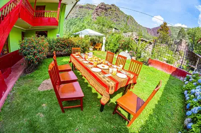 a table and chairs in the yard of a house at Happy Land Valle Sagrado in Urubamba
