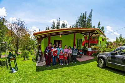 a group of people standing in front of a house at Happy Land Valle Sagrado in Urubamba