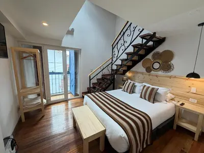 a bedroom with a large bed and a staircase at CASA CRISTOBAL Siete Cuartones in Cusco