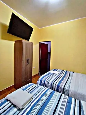 a bedroom with two beds and a cabinet in it at La Ruta in Paracas