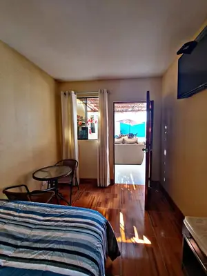 a bedroom with a bed and a table and a room at La Ruta in Paracas