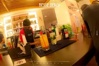 a woman standing at a counter in a bar at Besso Beach Hotel in Barranca