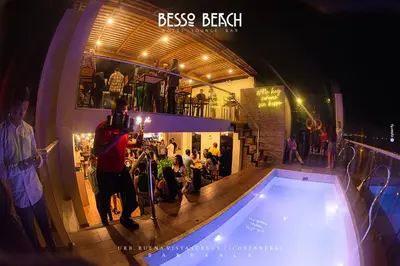 a man taking a picture of a swimming pool at night at Besso Beach Hotel in Barranca