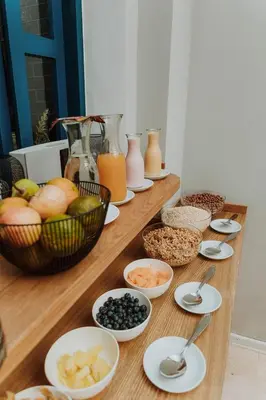 a wooden table topped with bowls of fruit and other foods at Kokoa Hotel Cusco in Cusco