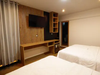 a hotel room with two beds and a flat screen tv at Platero Hotel in Ayacucho