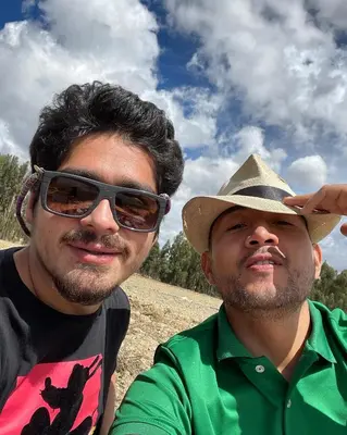 two men sitting next to each other wearing a hat at CasaHotel Laguna Jauja Airport in Jauja