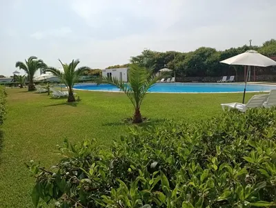 a resort with a pool and chairs and an umbrella at Depa de Playa en Asia in Asia