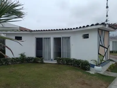 a white house with a lawn in front of it at Bungalow Jatun Mama in Ventanilla