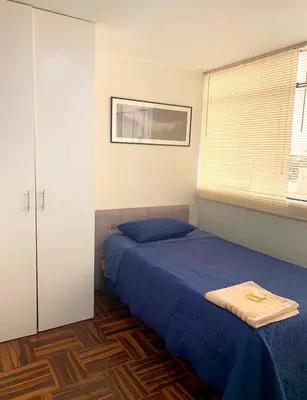 a bedroom with a blue bed and a window at Lindo departamento en Magdalena del Mar in Lima