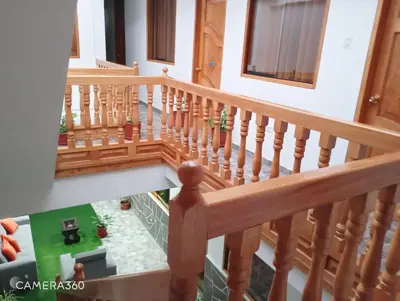 a stairway with a wooden rail and a house at Qente Wings in Ollantaytambo