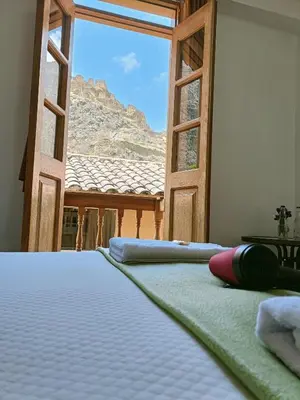 a bed in a room with a view of a mountain at Qente Wings in Ollantaytambo