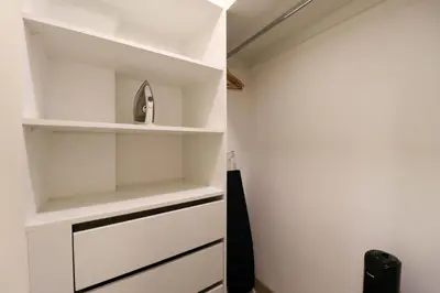 a walk in closet with white shelves at Grau by Wynwood House in Lima