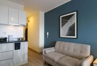 a living room with a couch and a kitchen at Grau by Wynwood House in Lima