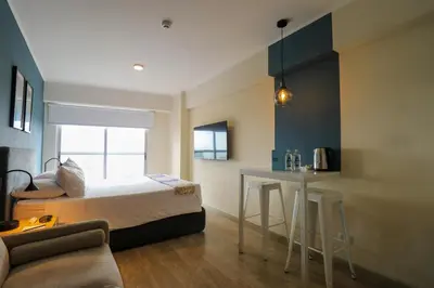 a bedroom with a bed and a table in it at Grau by Wynwood House in Lima