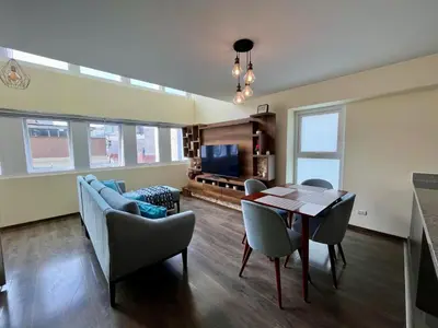a living room with a table and chairs and a couch at Elegante Duplex Cerca Parque Kennedy Miraflores in Lima