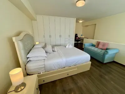 a bedroom with a bed and a blue chair at Elegante Duplex Cerca Parque Kennedy Miraflores in Lima