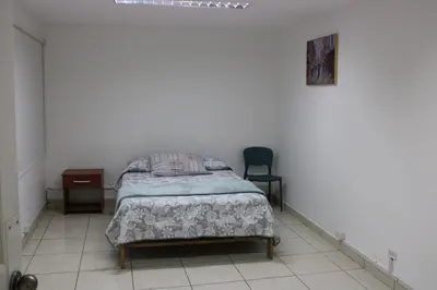 a bedroom with a bed and a chair in it at Hospedaje San Isidro 402 in Lima