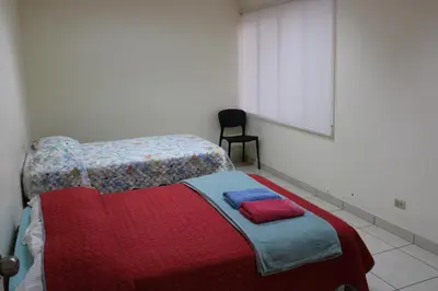 a bedroom with a bed with a red and blue blanket at Hospedaje San Isidro 402 in Lima