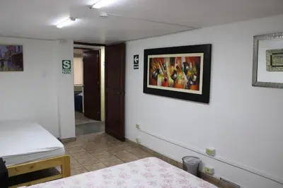 a bedroom with a bed and a painting on the wall at Hospedaje San Isidro in Lima