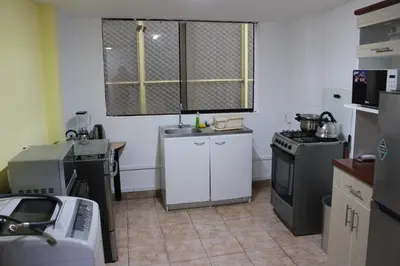 a kitchen with a sink and a stove at Hospedaje San Isidro in Lima
