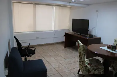 a living room with a table and a television at Hospedaje San Isidro in Lima